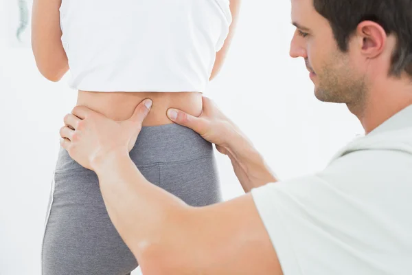 Mid sectie van een fysiotherapeut onderzoeken vrouw terug — Stockfoto