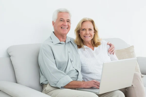 Avslappnad kärleksfull äldre par med laptop — Stockfoto