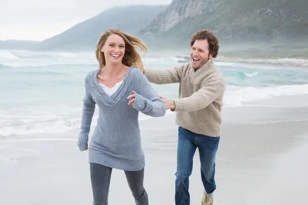 Glad par kör på stranden — Stockfoto