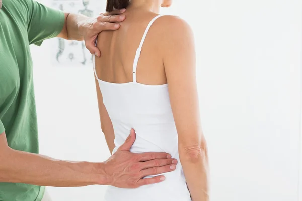 Fisioterapeuta examinando as costas da mulher no consultório médico — Fotografia de Stock