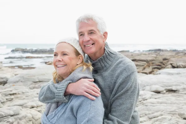 Romantic senior couple together on rocky beach — Stock Photo, Image