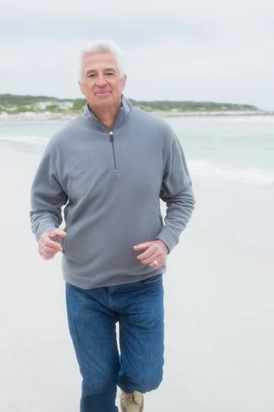 Портрет старшего бегущего по пляжу человека — стоковое фото