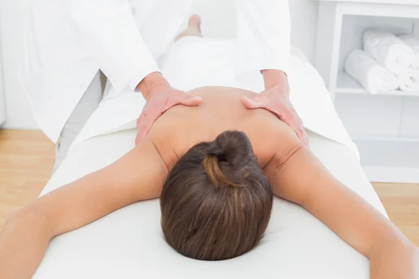 Fisioterapeuta masculino masajeando la espalda de la mujer — Foto de Stock