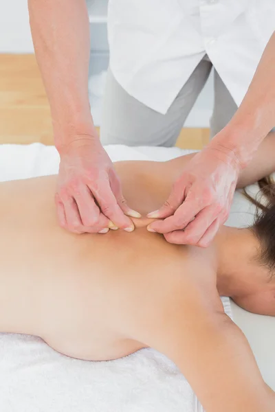 Fisioterapeuta masculino masajeando la espalda de la mujer — Foto de Stock