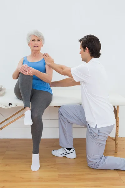 Physiothérapeute homme examinant le dos de la femme âgée — Photo