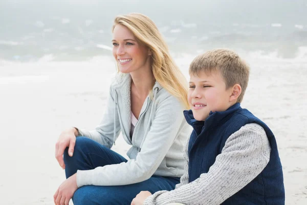 随便的女人和儿子放松在海滩 — 图库照片