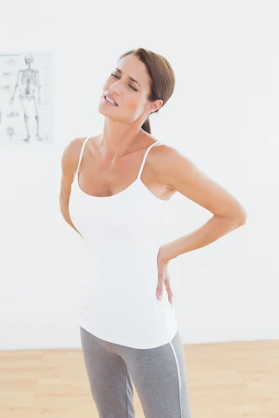 Beautiful young woman with back pain — Stock Photo, Image