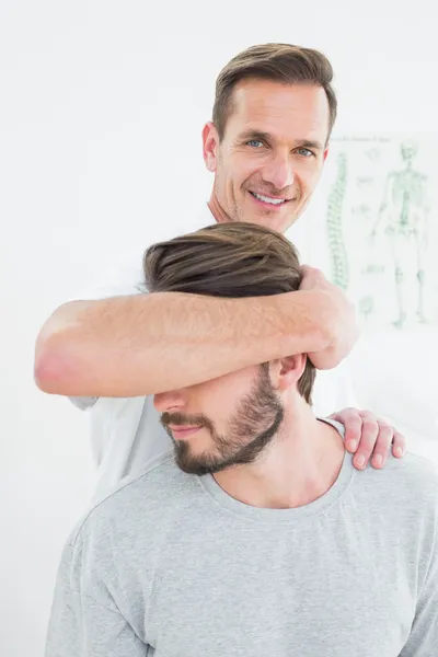 Retrato de um quiroprático do sexo masculino fazendo ajuste do pescoço — Fotografia de Stock