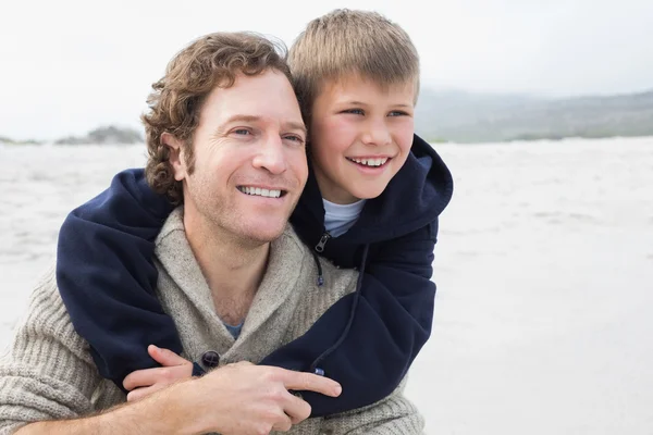 Uomo piggybacking suo figlio in spiaggia — Foto Stock