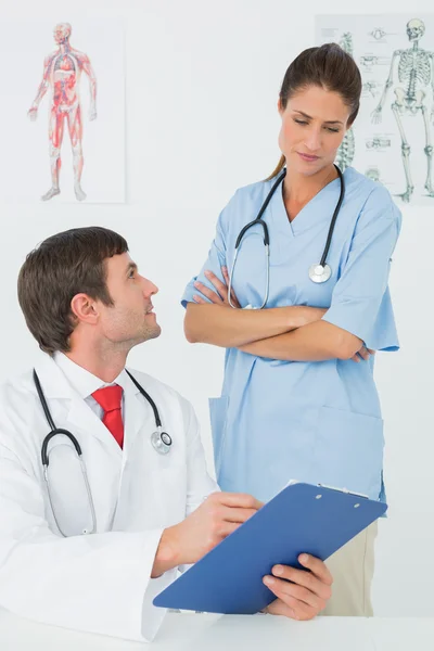 Doctors with reports in medical office — Stock Photo, Image