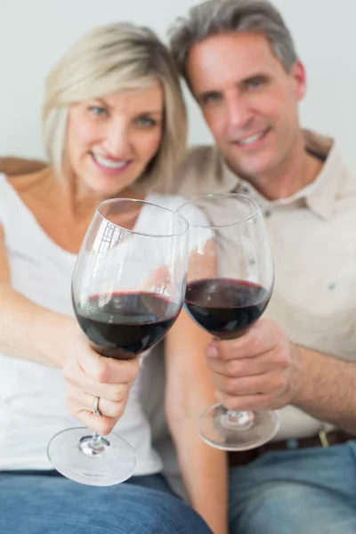 Happy couple holding out wine glasses — Stock Photo, Image