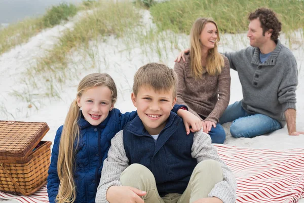 Familia feliz de cuatro en un picnic en la playa — Foto de Stock