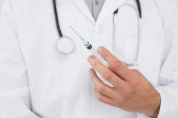 Mitten delen av en manlig läkare som innehar en injektion — Stockfoto