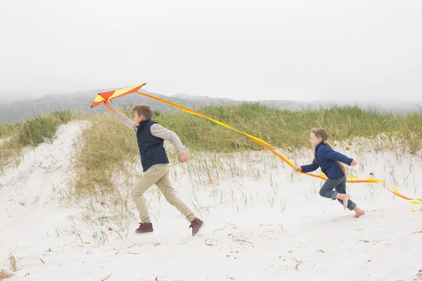Enfants joyeux courir avec cerf-volant à la plage — Photo