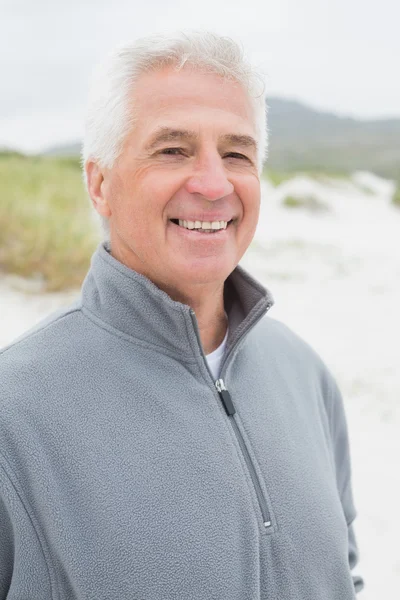 Smiling handsome casual senior man at beach — Stock Photo, Image