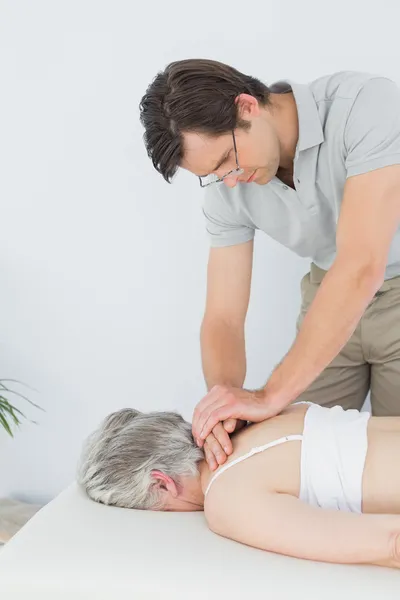 Mężczyzna fizjoterapeuty Masowanie starszego kobiety z powrotem — Zdjęcie stockowe