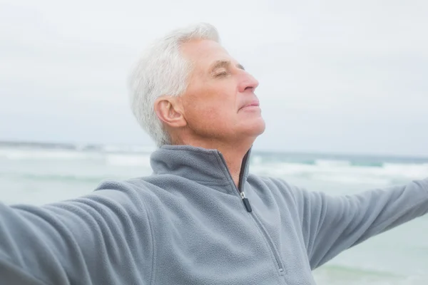 Senior man with arms outstretched at beach — Stock Photo, Image