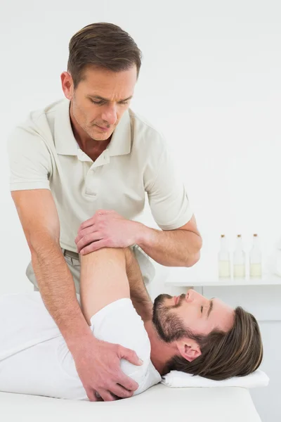 Fisioterapeuta masculino estirando la mano de un hombre —  Fotos de Stock