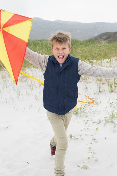 Fröhlicher Junge mit Drachen am Strand — Stockfoto