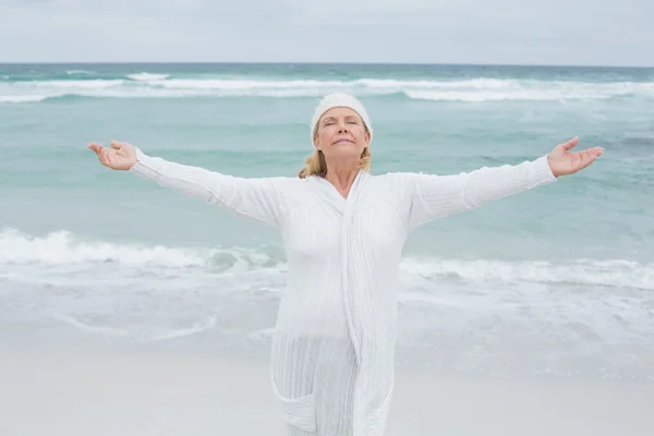 Senior woman with arms outstretched at beach — Stock Photo, Image