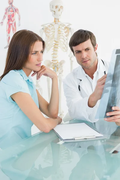 Médico varón explicando radiografía de columna vertebral al paciente femenino — Foto de Stock