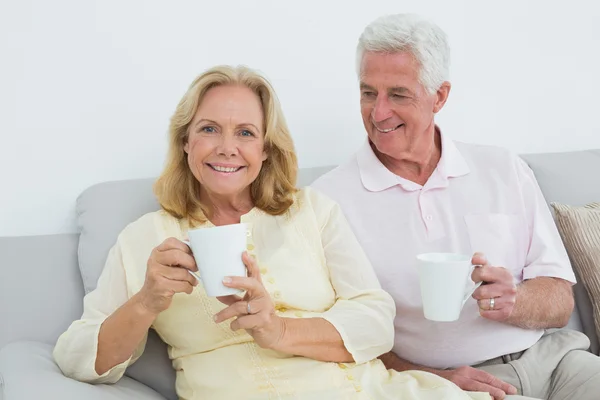 Entspanntes Seniorenpaar mit Kaffeetassen zu Hause — Stockfoto