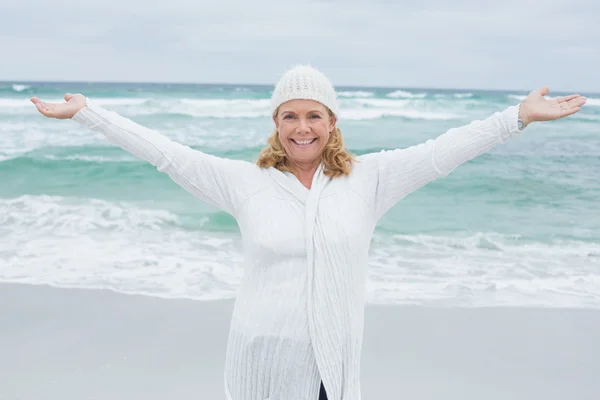 Starší žena s rukama nataženýma na pláži — Stock fotografie
