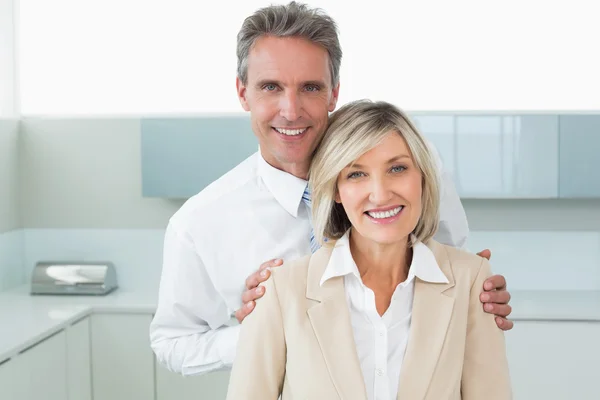 Man standing behind a happy woman in kitchen — Stock Photo, Image