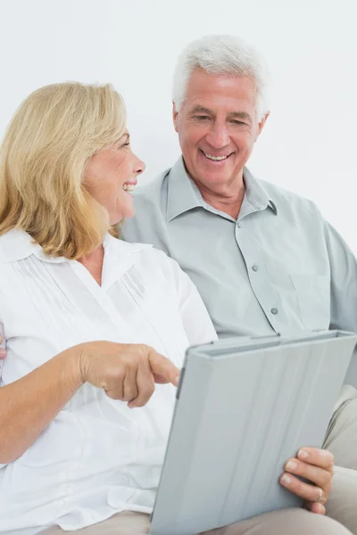 Casal idoso relaxado usando tablet digital em casa — Fotografia de Stock