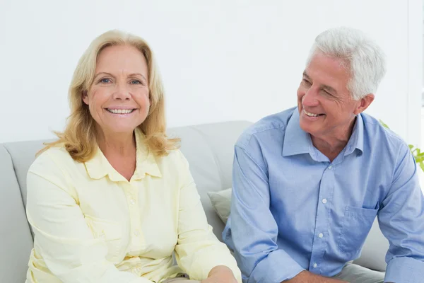 Happy senior couple sitting on sofa — Stock Photo, Image