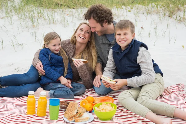 Happy family of four at a beach picnic — Stock Photo, Image