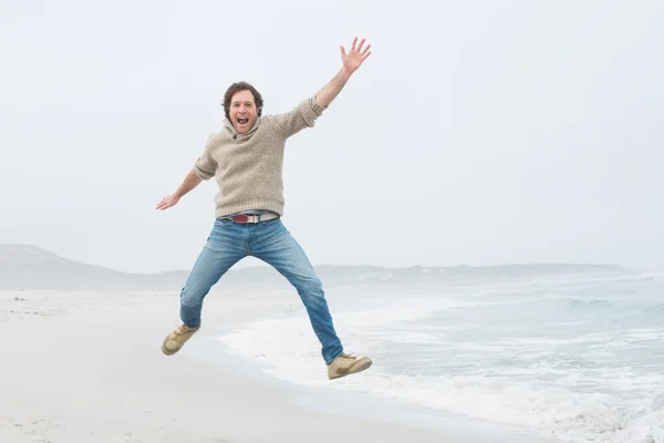 Portrait d'un jeune homme décontracté sautant à la plage — Photo