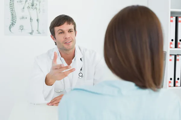 Médico escuchando al paciente con concentración en el consultorio médico — Foto de Stock