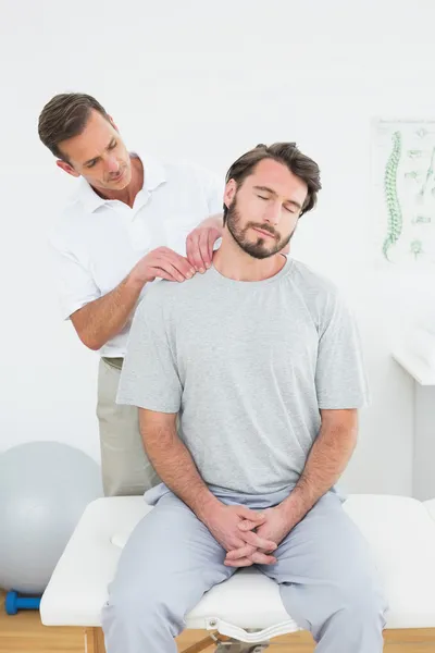 Male therapist massaging a content man's shoulders — Stock Photo, Image