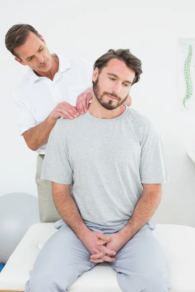 Male therapist massaging a content man's shoulders — Stock Photo, Image