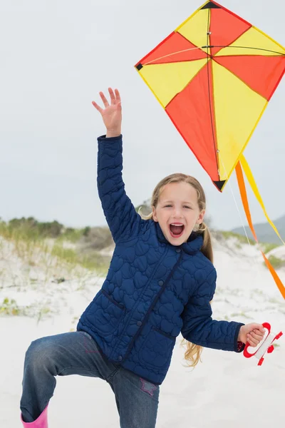 Fröhliches junges Mädchen mit Drachen am Strand — Stockfoto