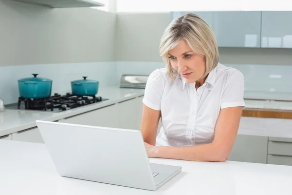 Jovem mulher Casual usando laptop na cozinha — Fotografia de Stock