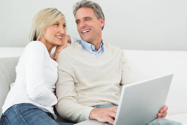 Pareja casual feliz usando el ordenador portátil en casa — Foto de Stock