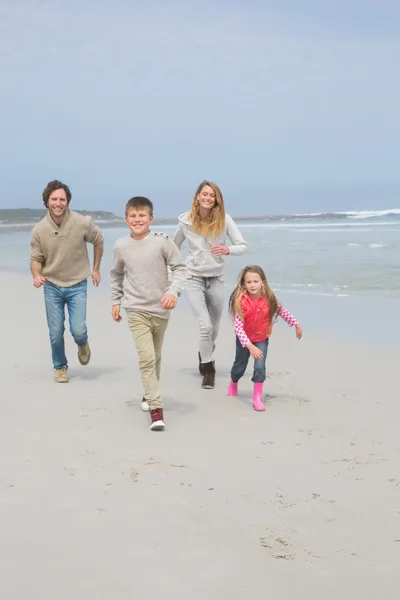 Happy family of four running at beach — Stock Photo, Image
