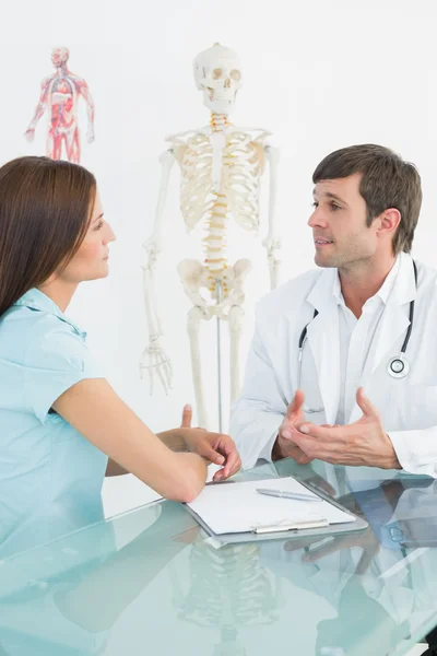 Médico varón escuchando al paciente con concentración en el escritorio — Foto de Stock