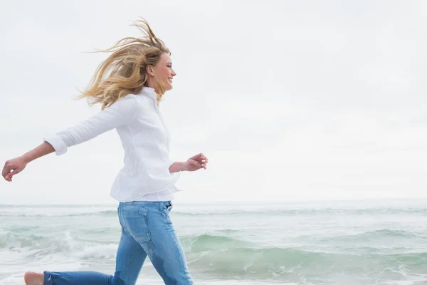 Vista lateral de uma mulher correndo na praia — Fotografia de Stock