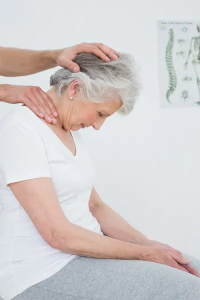 Mujer mayor haciendo el ajuste del cuello — Foto de Stock