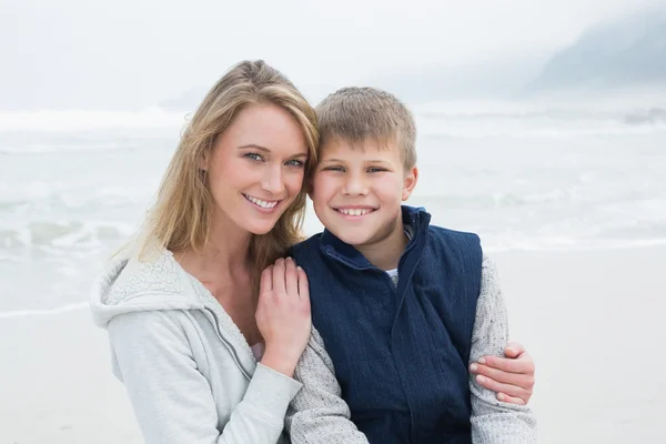 Schattige jongen met lachende moeder op strand — Stockfoto