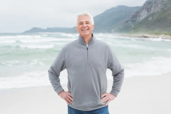 Feliz hombre mayor con las manos en las caderas en la playa — Foto de Stock