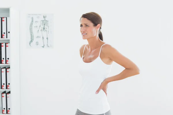 Side view of a beautiful young woman with back pain — Stock Photo, Image