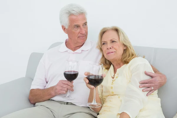 Ontspannen senior koppel met wijn glazen thuis — Stockfoto