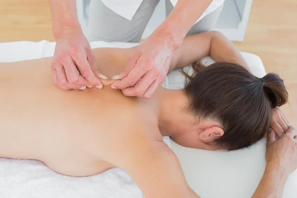 Fisioterapeuta masculino masajeando la espalda de la mujer — Foto de Stock