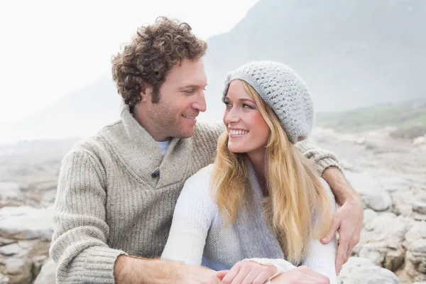 Lyckliga par sitter tillsammans på klippiga landskap — Stockfoto