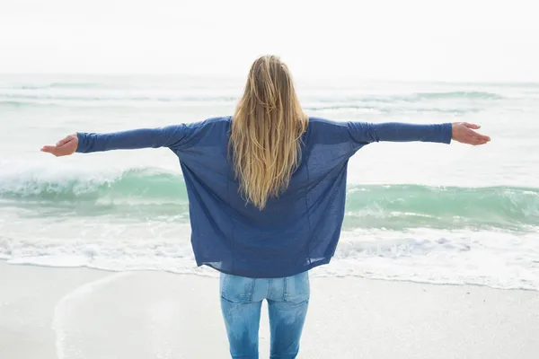 Вид ззаду блондинка з руками, витягнутими на пляжі — стокове фото