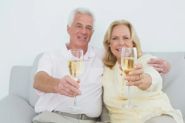 Seniorenpaar hält Sektflöten zu Hause — Stockfoto